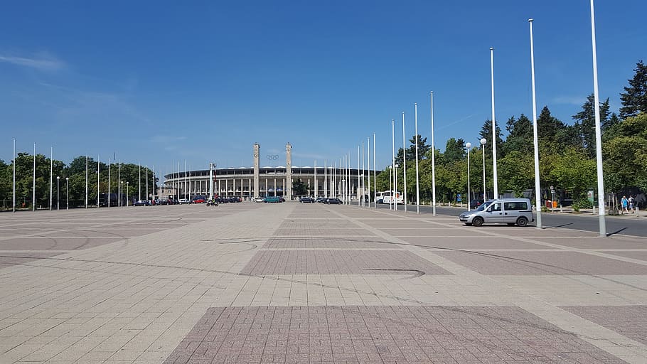 olympiske stadion, Berlin, stadion, himmel, transportmidler, arkitektur, natur, bygget struktur, motor køretøj, transportform, bil, træ, by, dag, gade, sollys, ingen mennesker, vejen frem, blå, skyfri himmel, retning, sti, land køretøj, udendørs, 5K