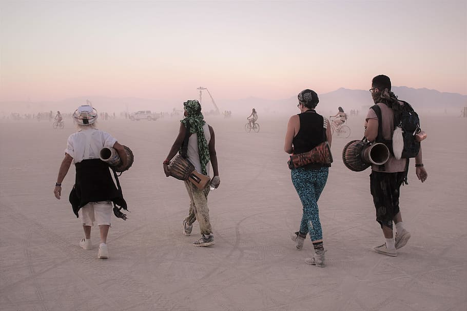 fire, person, gå, transporterer, trommer, to, herrer, Kvinder, percussion instrumenter, landskab felt, ørken, trommeslagere, gruppe, tåget, sand, Brændende mand, black rock city, planet, ensom, udforskning, hver dag, playa, fuld længde, solnedgang, gruppe af mennesker, voksen, mennesker, guitar, musik, musikinstrument, venskab, cool holdning, himmel, stående, kunstkultur og underholdning, ung voksen, afslappet tøj, kunstner, natur, 5K