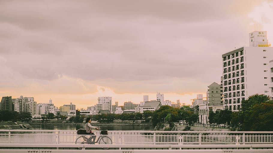 fotografia, persona, muntar a cavall, bicicleta, pont, arquitectura, edifici, infraestructura, cel, gratacels, torre, horitzó, urbà, ciutat, riu, aigua, gent, exterior de l'edifici, estructura construïda, núvol - cel, paisatge urbà, horitzó urbà, a l'aire lliure, naturalesa, exterior d’edifici d’oficines, cap gent, barri residencial, arbre, posta de sol, barana, alta - alta, paisatge, 5K