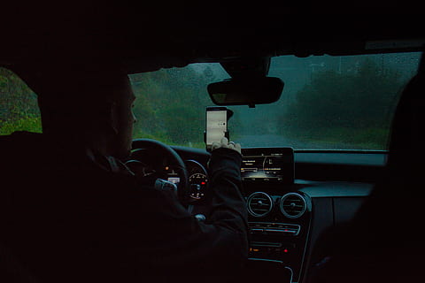person, driving, car, using, phone, man, smartphone, vehicle, windscreen, window, mode of transportation, transportation, vehicle interior, windshield, car interior, motor vehicle, land vehicle, glass - material, control panel, one person, steering wheel, road, indoors, on the move, dashboard, men, travel, transparent, 5K, CC0, public domain, royalty free