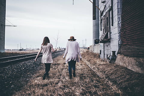 two, women, walking, grass field, beside, train rails, architecture, building, infrastructure, grass, people, girls, railway, track, travel, outdoor, field, friends, two people, adult, adults only, togetherness, casual clothing, day, young adult, railroad track, rear view, real people, full length, sky, nature, lifestyles, built structure, bonding, men, city, building exterior, outdoors, couple - relationship, 5K