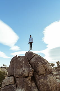 l'uomo salta, Marrone, masso, uomo, salto, roccia, blu, cielo, nube, bianca, roccia - oggetto, lunghezza intera, solido, una persona, in piedi, stili di vita, attività di svago, persone reali, abbigliamento casual, giorno, natura, giovane adulto, Inquadratura dal basso, bellezza nella natura, nuvola - cielo, donne, vista frontale, all'aperto, 8K, CC0, dominio pubblico, privo di copyright