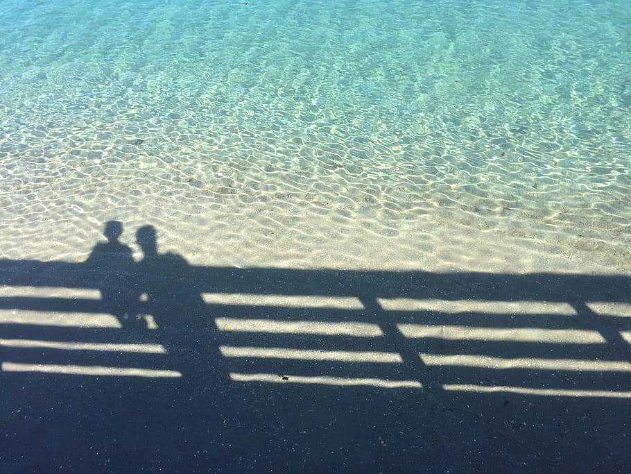 ombra, noi, home, tanca, dos, persona, oceà, illa de cacauet, mar, gent, platja, a l'aire lliure, viatjar, dues persones, vista d’angle alt, només adults, llum solar, naturalesa, aigua, una persona, persones reals, dia, persona irreconeixible, activitat d'oci, estils de vida, terra, tranquil·litat, barana, centrar-se en l'ombra, 2K