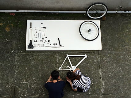 mand, kvinde, crouching, cykeldele, montering af en cykel, komponent, cykel, ovenfra, sort og hvid, konstruktør, detaljer, hjul, ur, tid, bagfra, herrer, voksen, to personer, mennesker, Kvinder, afslappet tøj, murbygningsfunktion, leder, indendørs, hanner, ung voksen, meddelelse, nøjagtighed, stribet, unge kvinder, arkitektur, stående, ser, vægur, uret ansigt, par - forhold, 2K, CC0, offentligt domæne, royaltyfrie