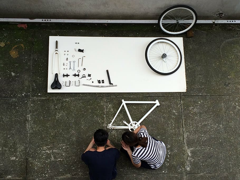 home, dona, agafat, parts de bicicletes, muntar una bicicleta, component, bicicleta, vista superior, blanc i negre, constructor, detalls, roda, rellotge, temps, vista del darrere, homes, adult, dues persones, gent, dones, roba casual, funció de construcció de parets, mirant, a l'interior, mascles, adult jove, comunicació, precisió, ratlles, dones joves, arquitectura, de peu, rellotge de paret, parella - relació, 2K