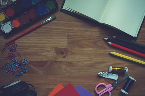 paleta de colors de l'aigua, al costat, vermell, raspall, clips, marró, sòl de parquet, pintura, quadern, llapis, paper d'escuma, fusta, fons, auriculars, dibuix, llibre, bolígraf, educació, acadèmic, feliç, espai de treball, lloc de treball, taula, a l'interior, vista d’angle alt, instrument d’escriptura, multicolor, art i artesania, natura morta, directament a sobre, paper, material de fusta, tisores, cap gent, gran grup d'objectes, variació, llapis de colors, grup d'objectes, artesania, elecció, grapadora, art i equipament artesanal, 2K, CC0, domini públic, lliure de regalies