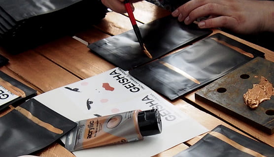 Person Malerei, Tabelle, Kunst, Verpackung, Design, Verpackungsdesign, Paket, Muster, Dekoration, Textur, dekorativ, Stil, drinnen, eine Person, Hand, menschliche Hand, menschliches Körperteil, High Angle View, Kunst und Handwerk, Pinsel, Bürste, halten, Text, Nahansicht, direkt darüber, Kreativität, Fertigkeit, Kalligraphie, Erwachsene, Papier-, 4K, CC0, gemeinfrei, lizenzfrei