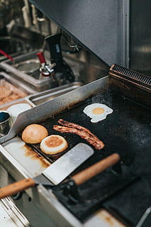 Person, die Speck kocht, Ei, Brot, gebraten, Wurst, Gebäck, Lebensmittel, Essen und Trinken, Vorbereitung, Frische, Gerät, Essen vorbereiten, drinnen, Küche, Hitze - Temperatur, Herd, High Angle View, selektiver Fokus, Haushaltsausstattung, Wohnraum, Wohlbefinden, keine Leute, Stillleben, gesundes Essen, Gewerbliche Küche, Pfanne, Bratpfanne, Backblech, Snack, 5K, CC0, gemeinfrei, lizenzfrei