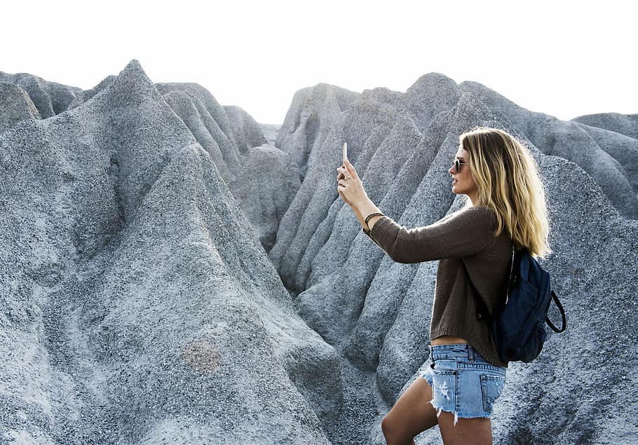 dona, de peu, Serra, telèfon, tecnologia, muntanya, dom, rock, viatjar, senderisme, naturalesa, campament, estil de vida, cap de setmana, somriu, alegre, somrient, cel·lular, turó, connexió, gadget, cel·la, pasatemps, viatge, turisme, felicitat, oci, diversió, lent, festa, turista, motxillers, disparar, a l'aire lliure, actiu, càlid, pic, plantes, paisatge, aventura, noia, feliç, casual, motxilla, viatger, activitat, fer una foto, comunicació, càmera, romàntic, gaudeix, foto, femella, dispositiu, senyora, smartphone, dones, femelles, rock - object, gent, una persona, adult jove, activitat d'oci, estils de vida, roba casual, persones reals, dones joves, bellesa a la natura, tres quarts de longitud, dia, escenics - natura, vista lateral, formació de roca, cabell, llibertat, 5K