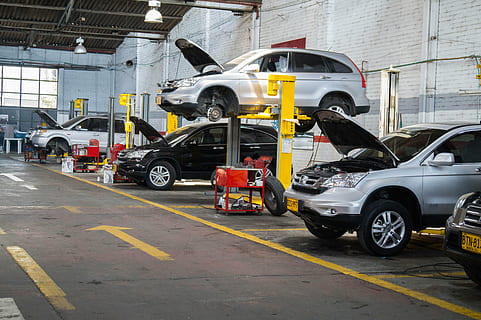 workshop, vehicles, maintenance, mode of transportation, transportation, motor vehicle, car, industry, occupation, land vehicle, day, working, repairing, architecture, factory, people, technology, road, built structure, equipment, business, yellow, motion, 5K, CC0, public domain, royalty free