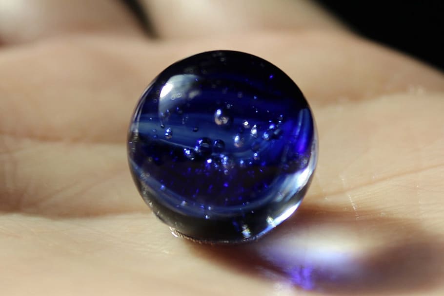 mà, bola de marbre, blau, esfera, primer pla, marbres, part del cos humà, mà humana, una persona, a l'interior, reflexió, brillant, part del cos, marbre, celebració, centrar-se en primer pla, tir de l'estudi, enfocament selectiu, dit, dit humà, porpra, luxe, 1080P