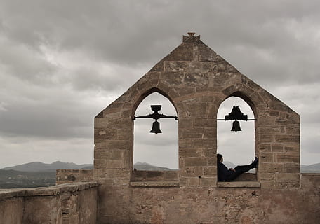 persona, assegut, marró, concret, finestra, arquitectura, edifici, paret, façana, Església, campanar, barri antic, monument, història, pedres, maçoneria, timbre, viatjar, mallorca, espanya, cel, núvols, paisatge, ruïna, malalt, perspectiva, vista, mirant, visió, punt de vista, ampli, trist, temps, núvols foscos, núvols de tempesta, formen núvols, coberta de núvols, dona, seure, preocupacions, relax relax, descans, descansa la pausa, campanes, arcs, capdepera, castell, fortalesa, burgruina, núvol - cel, estructura construïda, exterior de l'edifici, lloc de culte, religió, creença, espiritualitat, creu, el passat, campanar - torre, dia, naturalesa, cap gent, a l'aire lliure, paret de pedra, 4K, CC0, domini públic, lliure de regalies
