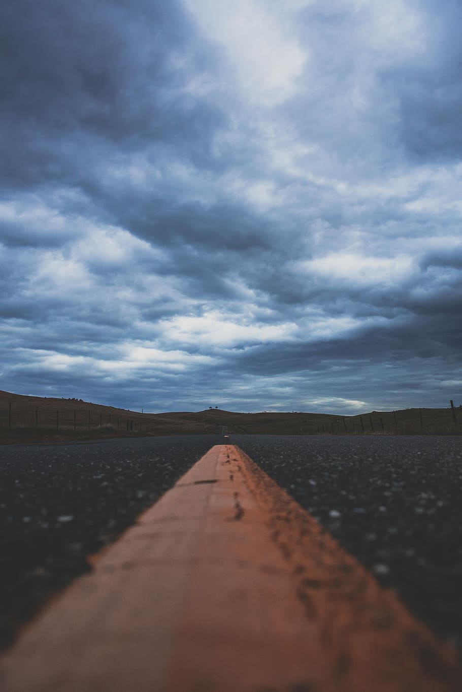 Basso, fotografia ad angolo, grigio, calcestruzzo, strada, nubi cumuliformi, giallo, linea stradale, cielo, nube, tempesta, collina, orizzonte, nuvola - cielo, la strada davanti, direzione, prospettiva decrescente, natura, punto di fuga, mezzi di trasporto, scenics - natura, nessuno, livello di superficie, scena tranquilla, giorno, all'aperto, bellezza nella natura, paesaggio, la tranquillità, messa a fuoco selettiva, terra, lungo, 5K
