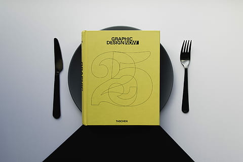 gràfic, disseny, llibre, negre, placa, groc, ceràmica, taula, plat, forquilla, ganivet, mínim, minimalisme, blanc, pis pla, disseny gràfic, taschen, tapa de taula, configuració de la taula, vista superior, minimalista, menjar, utensili per menjar, ganivet de taula, estri de cuina, a l'interior, equipament per a la llar, natura morta, text, cap gent, primer pla, grup d'objectes, tir de l'estudi, vista d’angle alt, comunicació, paper, directament a sobre, configuració de lloc, configuració, petit grup d'objectes, 5K
