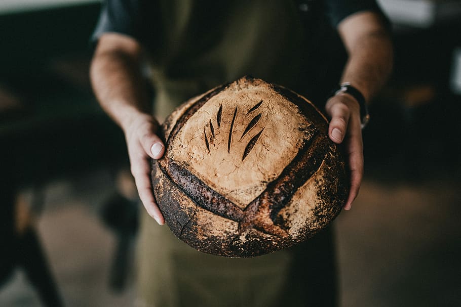 Person, halten, getoastet, Brot, braun, Kokosnussfrucht, Bäckerei, Laib, Hand, Essen und Trinken, Lebensmittel, eine Person, Nahansicht, Mittelteil, Erwachsene, Fokus auf den Vordergrund, gesundes Essen, menschliche Hand, menschliches Körperteil, Wohlbefinden, Frische, Vorderansicht, Obst, einzelnes Objekt, Tag, Männer, 5K
