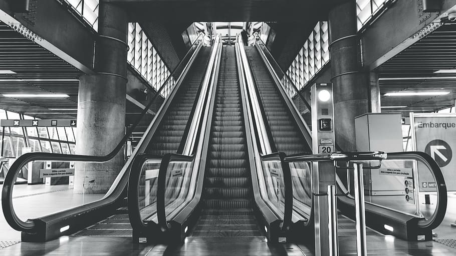grayscale photo, escalators, architecture, building, infrastructure, structure, establishment, escalator, stairs, station, black and white, monochrome, transportation, subway train, subway station, indoors, mode of transport, staircase, industry, modern, illuminated, railing, convenience, technology, rail transportation, public transportation, built structure, mode of transportation, steps and staircases, connection, metal, absence, no people, moving walkway, ceiling, 5K