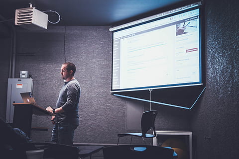 persona, en pie, frente, marrón, atril, hombre, ordenador portátil, presentación, profesor, salón de clases, clase, PowerPoint, tecnología, una persona, computadora, comunicación, gente real, pantalla, tres cuartos de longitud, monitor de computadora, sentado, adentro, machos, conexión, ropa casual, trabajando, hombres, oficina, adulto, tecnología inalámbrica, 5K, CC0, dominio público, libre de derechos