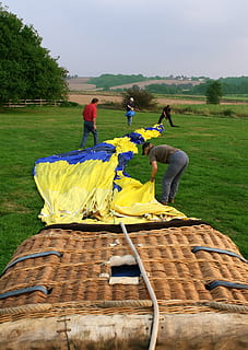 Luft- und Raumfahrt, Luft, Flugzeug, aufsteigen, Luftfahrt, Ball, Ballon, Ballonfahren, Korb, Nieder, Drift, fallen, Feuer, Flamme, Flug, schweben, fliegen, fliegend, Spaß, Geschirr, Hitze, heiß, heiße Luft, Land, Aufzug, aus, Pilot, angetrieben, Fortschritt, retro, Reiten, Takelwerk, erhebt euch, sicher, segeln, Himmel, Sport, Erfolg, Transport, Reise, oben, Warme Luft, Wind, Menschen, Asien, Kulturen, Pflanze, echte Menschen, Gruppe von Leuten, Gras, Natur, Feld, Männer, Tag, Baum, Schönheit in der Natur, grüne Farbe, Lebensstile, draußen, Gelb, zufällige Menschen, Freizeitbeschäftigung, Kleidung, 2K, CC0, gemeinfrei, lizenzfrei