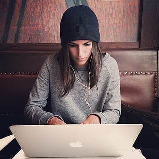 mujer, vistiendo, negro, tejer, gorra, propensión, macbook, ordenador portátil, manzana, computadora, navegador, investigación, estudiar, colegio, negocio, trabajo, escritorio, gente, niña, tecnología inalámbrica, una persona, tecnología, vista frontal, conexión, gente real, adentro, sentado, adulto joven, comunicación, ropa, mujer joven, ropa casual, usando laptop, estilos de vida, actividad de ocio, auriculares, peinado, navegando en la red, mujer hermosa, 1080P, CC0, dominio público, libre de derechos