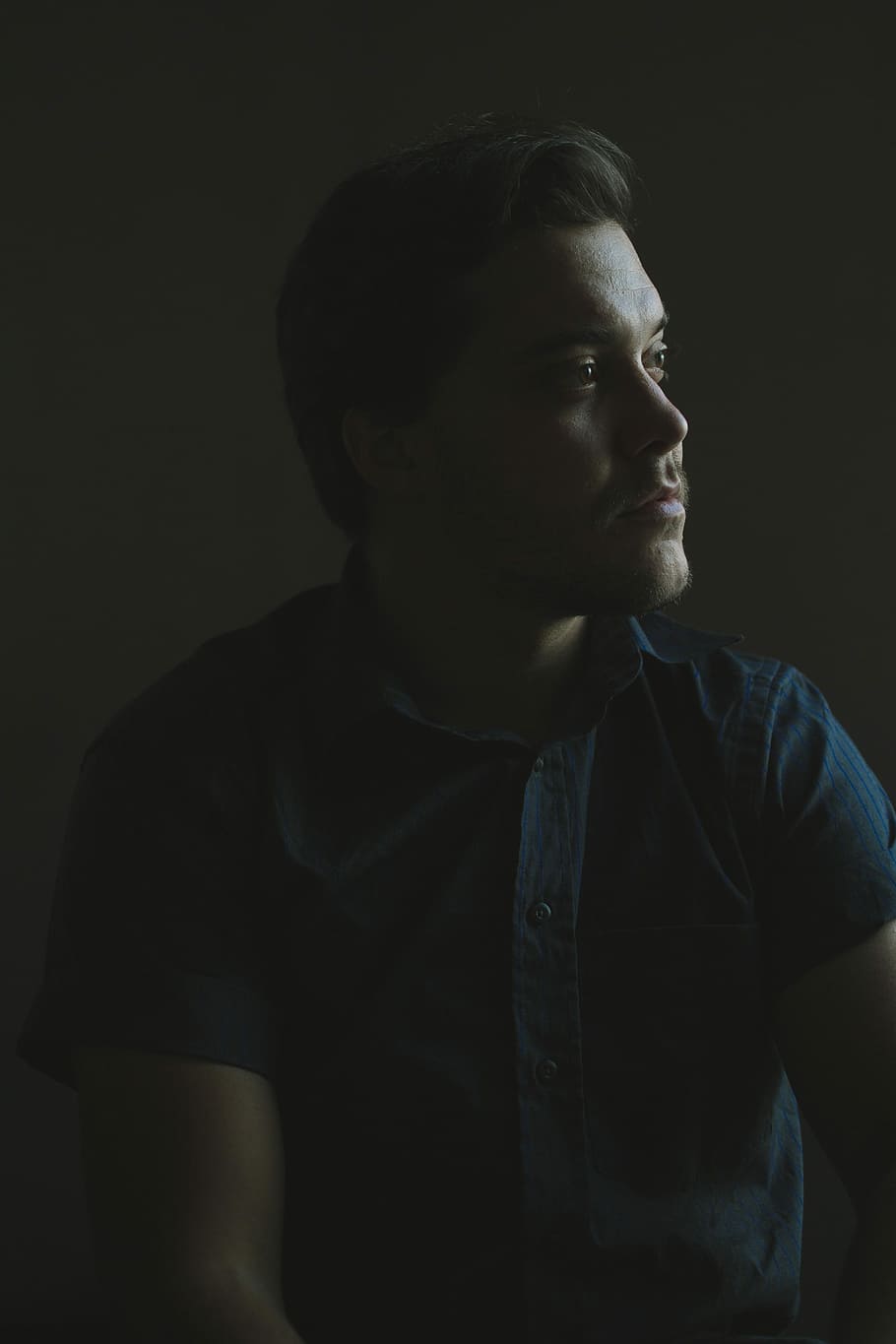 Mann, tragen, Blau, zuknöpfen, ergattert, Kurzarmhemd, oben, starrte, links, Seite, männlich, Gesicht, Schatten, dunkel, Hemd, schwarz, Brasilien, analog, Kodak Portra, portra, fuji, Pentax, Ton, eine Person, Studioaufnahme, drinnen, suchen, junger Erwachsener, Vorderansicht, Legere Kleidung, schwarzer Hintergrund, Wegschauen, junge Männer, Lebensstile, Porträt, Taille hoch, ernst, Betrachtung, Kopfschuss, Stehen, echte Menschen, 4K