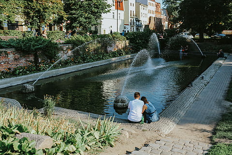 building, covered, vine, Old, architecture, street, red brick, outdoors, people, water, fountain, child, color Image, two people, togetherness, adult, mid adult, day, plant, tree, real people, men, nature, sitting, lifestyles, leisure activity, built structure, lake, males, casual clothing, couple - relationship, positive emotion, 5K