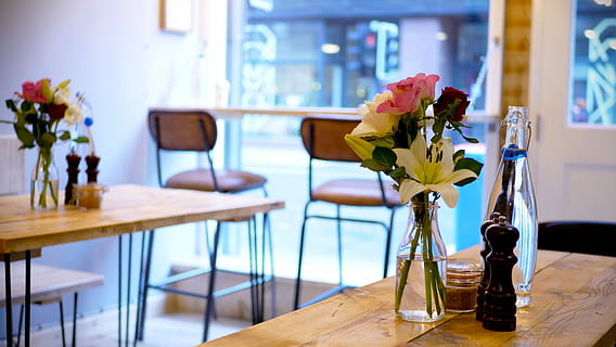 Cafe Interieur, Rosa, Weiß, Rosen, Vase, platziert, braun, hölzern, Tabelle, Stühle, Cafe, Café, Bar, blühende Pflanze, Blume, drinnen, Frische, Pflanze, Schönheit in der Natur, Dekoration, Natur, Zerbrechlichkeit, Möbel, Sitz, Verletzlichkeit, Wohngebäude, Blumenschmuck, Wohnraum, Stuhl, Blütenkopf, keine Leute, Blumenstrauß, Strauß, Glas, 5K, CC0, gemeinfrei, lizenzfrei
