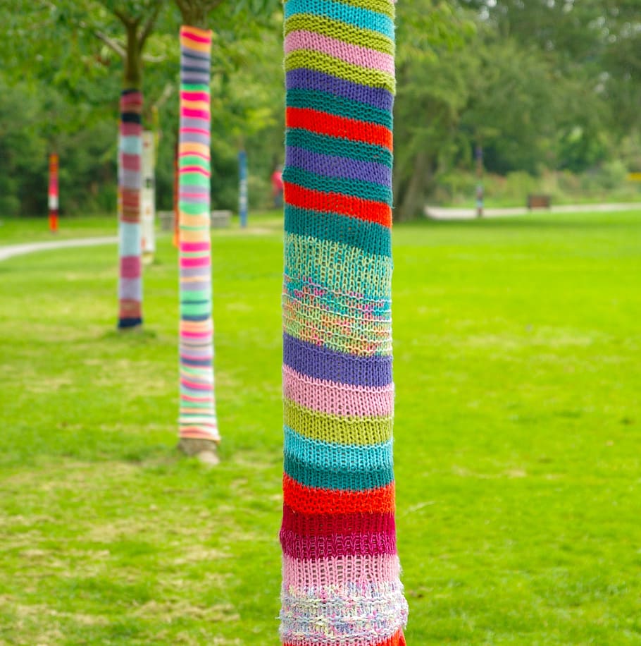 kunst, træer, strikning, kufferter, græsplæne, udendørs, multi farvet, græs, tekstil, uld, plante, fokus på forgrunden, ingen mennesker, stribet, Kunst og håndværk, dag, mønster, kreativitet, grøn farve, materiale, natur, håndværk, parkere, træstamme, lilla, 2K