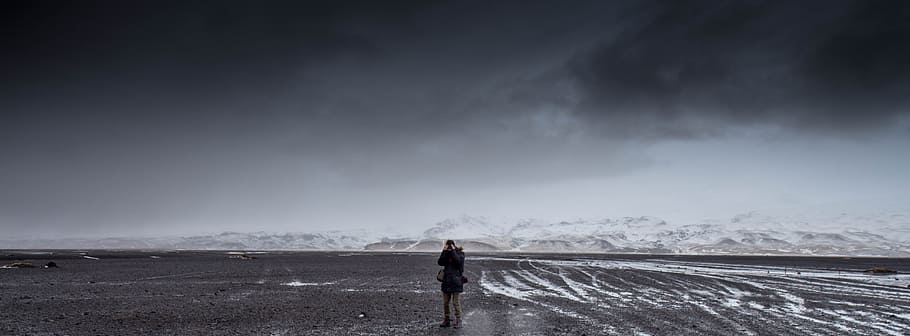 mand, stående, grå, dessert, overskyet, himmel, dagtimerne, skyer, bjergkæde, bjerge, panoramisk, person, fotograf, en person, scenics - natur, sky - himmel, skønhed i naturen, natur, miljø, fuld længde, storm, sne, kold temperatur, fritidsaktivitet, landskab, bagfra, jord, ferier, vinter, udendørs, ekstremt vejr, regn, 5K