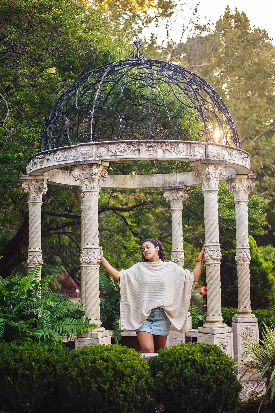 fotografia, donna, detenzione, post gazebo, in piedi, gazebo, struttura, architettura, pavillion, colonna, pilastro, una persona, pianta, natura, persone reali, albero, attività di svago, abbigliamento casual, stili di vita, vista frontale, giorno, adulto, ritratto, crescita, lunghezza intera, giardino, sorridente, metà adulto, all'aperto, 5K