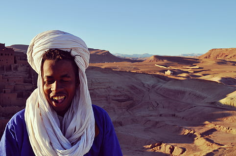 lächelnd, Mann, Berg, Wüste, Nomade, Marrakesch, Marokko, Sand, Reise, nomadisch, Tier, Tierwelt, wild, Zoologie, Säugetier, Spezies, Wildnis, Umgebung, draußen, Natur, eine Person, Porträt, Kopfschuss, Freizeitbeschäftigung, Sonnenlicht, Vorderansicht, Kleidung, Lebensstile, Erwachsene, Tag, Emotion, Himmel, Kamera betrachten, Glück, trockenes Klima, Klima, Mund offen, 4K, CC0, gemeinfrei, lizenzfrei
