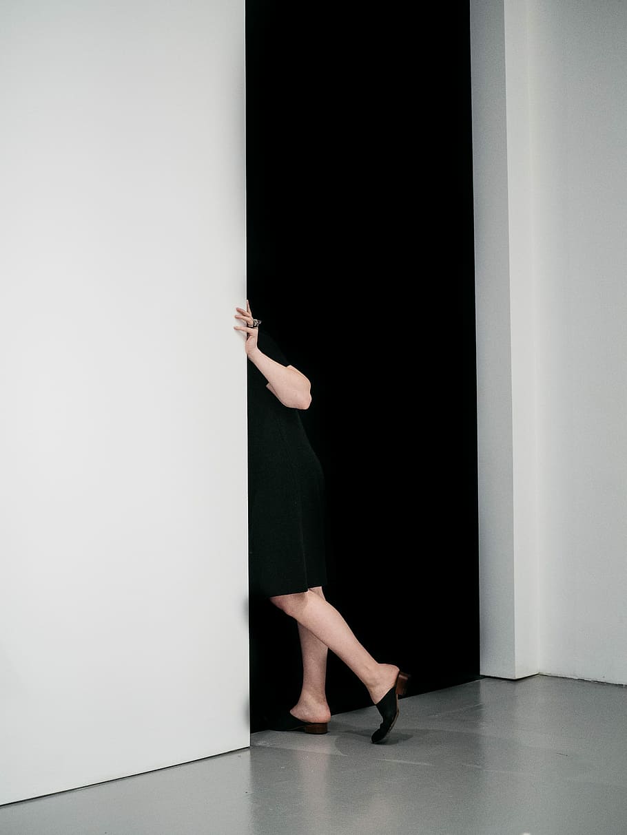 dona, de peu, furtivament, porta, endins, blanc, pintat, habitació, negre, vestit, màxim, al costat, paret, una persona, adult, a l'interior, longitud completa, dones, dona de negocis, part del cos humà, part del cos, negoci corporatiu, membre, extremitat humana, persona de negocis, cama humana, braç humà, funció de construcció de parets, secció baixa, braços aixecats, sòls, 4K