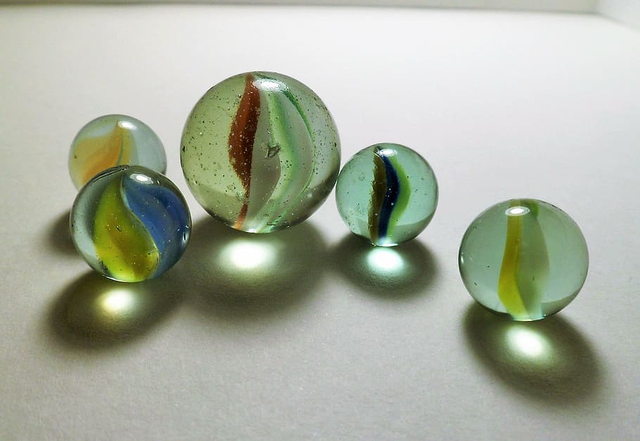 cinc joguines de marbre, marbres, pilotes, transparència, decoració, brillantor, vidre, colors, gotes, joieria, brillant, variació, pedres precioses, luxe, joia preciosa, reflexió, color verd, primer pla, natura morta, grup d'objectes, a l'interior, cap gent, esfera, multicolor, taula, elecció, forma, forma geomètrica, grup mitjà d'objectes, cercle, disseny, grup, accessori personal, 2K