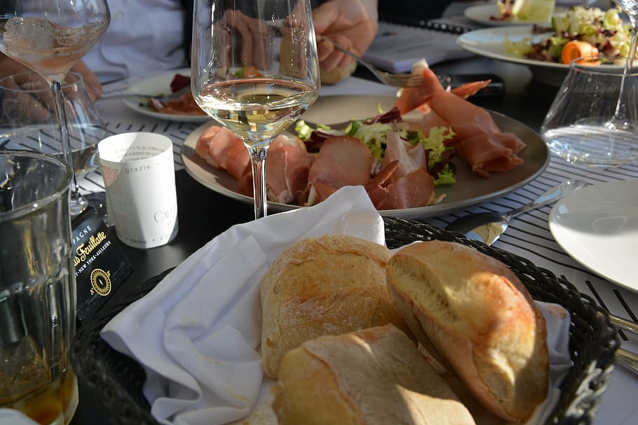 un pan, comer, poder, mesa, comida, plato, cena, celebracion, restaurante, comida y bebida, vaso, refresco, beber, frescura, Copa de vino, gente real, equipo doméstico, carne, adentro, vino, mano, vista de alto ángulo, alcohol, mano humana, 5K