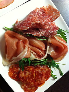 tapas, forret, skinke, salami, lækker, bidder, mad, spise, appetitvækkende, skære, hjertelig, gourmet, måltid, kød, aftensmad, friskhed, plade, mad og drikke, klar til at spise, tæt på, indendørs, portionsstørrelse, sund kost, høj vinkel visning, grøntsag, stilleben, bord, ingen mennesker, forarbejdet kød, svinekød, velvære, tomat, urt, pynt, arugula, porcelæn, 2K, CC0, offentligt domæne, royaltyfrie
