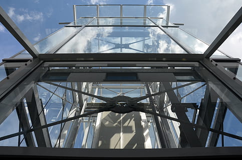 baix, fotografia d'angle, edifici de vidre, transport, ascensor, tecnologia, construcció, metall, gris, blau, modern, vidre, vista d’angle baix, arquitectura, estructura construïda, cel, dia, cap gent, vidre - material, naturalesa, núvol - cel, patró, transparent, a l'aire lliure, llum solar, edifici, exterior de l'edifici, claraboia, connexió, directament a sota, sostre, 4K, CC0, domini públic, lliure de regalies