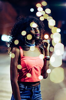 kvinne, iført, rød, avling, topp, stående, bygning, kvinner stirrer sidelengs, modell, afro, bokeh, hender, bangles, én person, belyst, ekte folk, tre kvart lengde, livsstil, fritidsaktivitet, uformelt antrekk, ung voksen, kvinner, forfra, unge kvinner, natt, portrett, glødende, fokusere på forgrunnen, belysningsutstyr, voksen, holding, frisyre, lysskjær, lys, 5K, CC0, offentlig domene, opphavsrett gratis