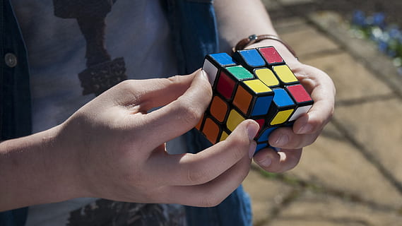 terning, Rubik, dreng, gåde, finger, ungdom, hånd, ung, multi farvet, dag, en person, udendørs, bedrift, sollys, menneskelig hånd, menneskelig kropsdel, fokus på forgrunden, fritidsaktivitet, tæt på, voksen, kropsdel, terningform, midsection, arkitektur, livsstil, legetøj, variation, menneskelig lem, 2K, CC0, offentligt domæne, royaltyfrie