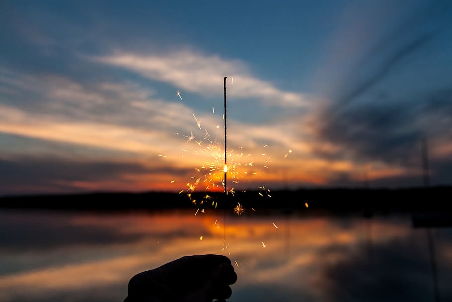 persona, celebració, vela romana, sparkler, llums, foc, flama, posta de sol, núvols, cel, naturalesa, fora, reflexió, llac, vespre, aigua, núvol - cel, silueta, color taronja, bellesa a la natura, una persona, escenics - natura, tranquil·litat, escena tranquil·la, idíl·lic, persones reals, a l'aire lliure, activitat d'oci, escena no urbana, 4K