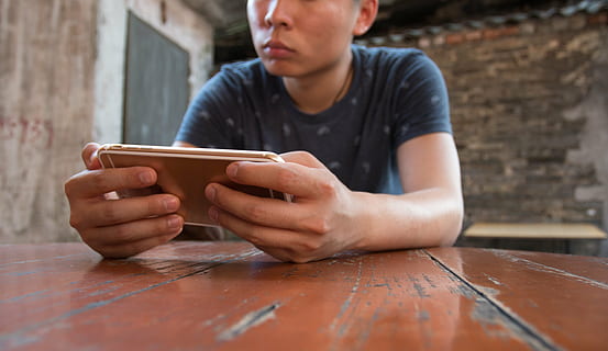 uomo che tiene il telefono, mobile, macro, mano, gioco, i phone, uomini, tecnologia, cellulare, una persona, smart phone, tecnologia wireless, persone, Internet, maschi, adulto, stili di vita, seduta, tavolo, giovane adulto, messaggistica testuale, abbigliamento casual, comunicazione, vista frontale, analizzare, cercare, guardare, connessione, detenzione, in casa, legno - materiale, tavoletta digitale, dispositivo di informazione portatile, guardando giù, giovani uomini, occupazione, livello di superficie, 5K, CC0, dominio pubblico, privo di copyright