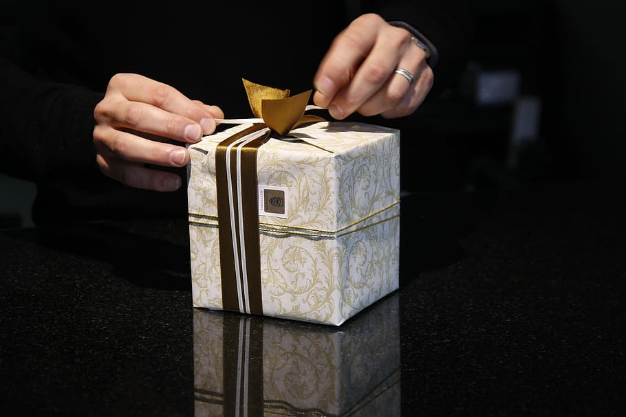 blanc, gris, Caixa de regal, persona, mà, Caixa, regal, envasos, bucle, Nadal, regalar, aniversari, fet, decoració, donar, compres de Nadal, imperi, desitjos, joia, embalat, mans, paquet, paper de regal, Festival, celebració, mà humana, misteri, moneda, una persona, un sol home, riquesa, part del cos humà, a l'interior, Finances, secció mitjana, primer pla, adult, fons negre, negocis, persona irreconeixible, color daurat, material de fusta, homes, inversió, dit, 1080P