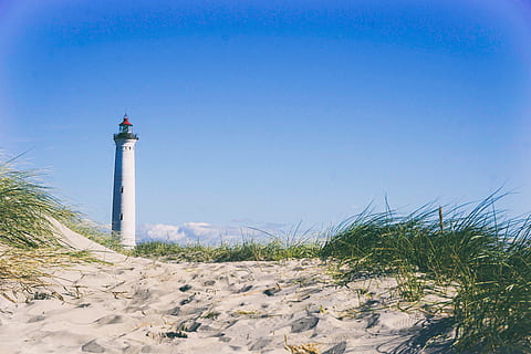 blanc, far, voltant, herba, núvols de cúmuls, foto, platja, sorra, mar, cel, línia de costa, llocs de viatges, blau, cap gent, lloc famós, naturalesa, a l'aire lliure, torre, paisatge, direcció, orientació, seguretat, protecció, arquitectura, estructura construïda, duna de sorra, cel clar, exterior de l'edifici, dia, terra, viatjar, destinacions de viatge, còpia espai, enterrat, 5K, CC0, domini públic, lliure de regalies