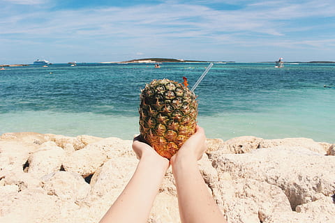 pineapple, dessert, appetizer, fruit, juice, crop, beach, ocean, sea, sand, waves, rocks, horizon, coast, human body part, water, one person, land, body part, adult, food and drink, human hand, sky, hand, nature, leisure activity, limb, holding, personal perspective, human limb, outdoors, human arm, 5K, CC0, public domain, royalty free