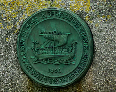 Normandie, Barfleur, William der Eroberer, Nahansicht, keine Leute, Text, Darstellung, Kunst, Schnitzen - Handwerksprodukt, Metall, Kreis, Tag, Kommunikation, Kunst und Handwerk, westliche Schrift, Geometrische Figur, menschliche Darstellung, gestalten, alt, Kreativität, draußen, grüne Farbe, 2K, CC0, gemeinfrei, lizenzfrei
