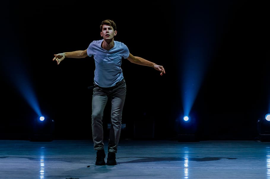 hombre, en pie, escenario, actuación, actor, bailarín, danza, longitud total, etapa - espacio de actuación, adulto joven, cultura de las artes y entretenimiento, vista frontal, adentro, una persona, adulto, jóvenes, brazo humano, evento de artes escénicas, hombres, miembro, iluminado, luz de escenario, extremidad humana, brazos levantados, 4K