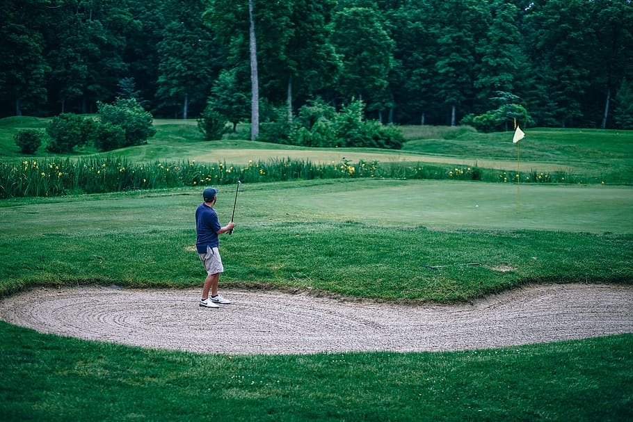 muž hraje golf, strom, zelená, modrý, vlajka, písek, golf, chlap, kámo, mužský, muž, rostlina, volnočasové aktivity, plná délka, sport, skutečných lidí, zelená barva, tráva, jedna osoba, muži, životního stylu, den, Příroda, neformální oblečení, hraní, aktivita, víkendové aktivity, stojící, venku, zelené - golfové hřiště, 5K