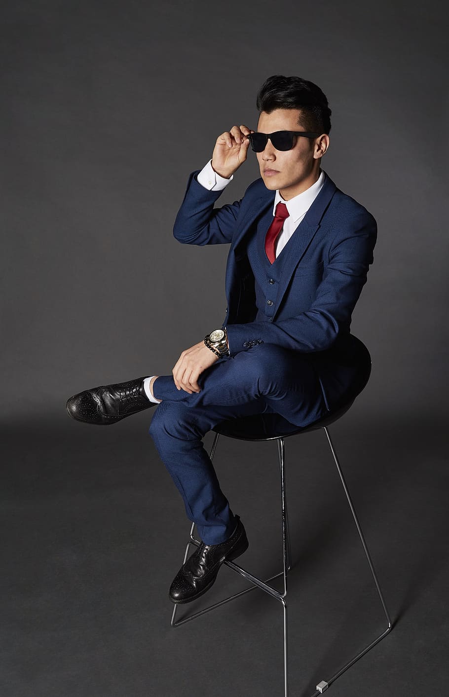 home, assegut, cadira, celebració, ulleres de sol, model, home de negocis, corporatiu, maco, retrat, adult, paio, elegant, estil de vida, moda, masculí, gent, jove, cara, professional, atractiu, de moda, homes, luxe, feliç, roba, modern, èxit, estil, desgast, cap, negocis, vestit, confiat, persona, cabell, gestor, professió, lideratge, treball en equip, pentinat, tall de cabell, contemporani, corbata, bon aspecte, humà, amics, de peu, social, sessió de fotos, formal, Reial, sabates, longitud completa, una persona, mascles, home jove, gots, a l'interior, adult jove, tir de l'estudi, ben vestit, ocupació, persona de negocis, gris, fons gris, 5K