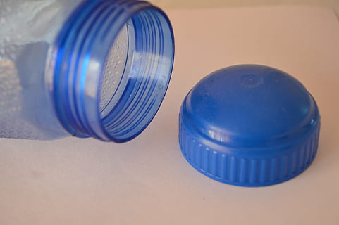 bottle, cap, plastic, blue, indoors, close-up, studio shot, no people, container, focus on foreground, copy space, two objects, group of objects, table, still life, four objects, recycling, chemistry, glass - material, lid, three objects, small group of objects, 5K, CC0, public domain, royalty free