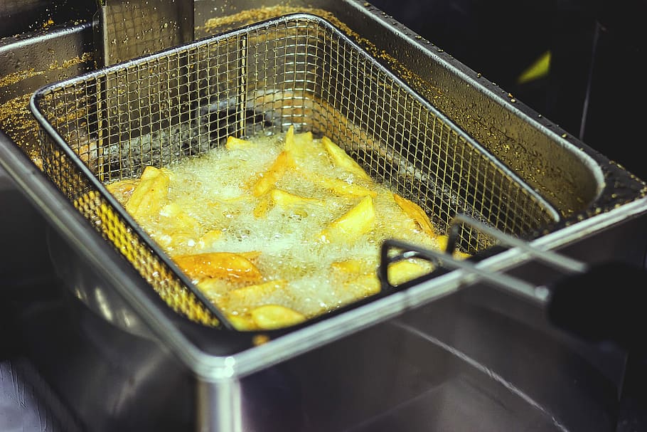 tallar les rodanxes de patates, profund, fregidora, patates fregides, cistella, submergit, bullint, olis, fregir, pan, xips, patata, menjar escombraria, menjar, menjar i beguda, preparació, a l'interior, calor - temperatura, cap gent, frescor, metall, vista d’angle alt, preparar el menjar, groc, fàbrica, planta de processament d'aliments, cuinant oli, Indústria alimentària i de begudes, negocis, oli, estri de cuina, 5K