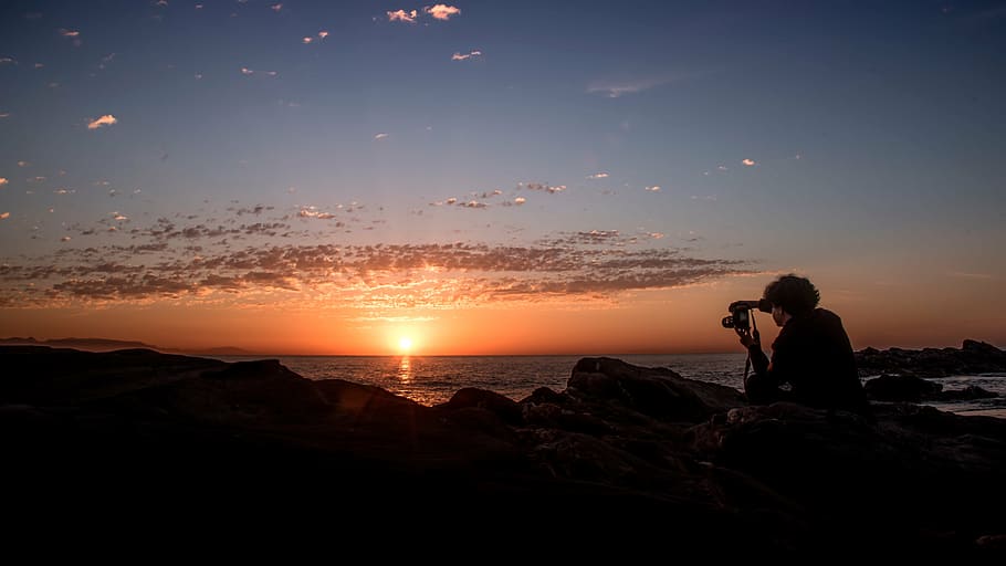 siluetă, persoană, deținere, aparat foto, de aur, ora, zori de zi, plajă, nori, cer, soare, stâncă, fotograf, albastru, aur, orizont, apus de soare, nisip, mare, frumuseţe, pace, observarea, tapet, apă, răsărit pe mare, o persoana, solid, obiect de rocă, frumusețe în natură, adult, natură, teren, ședință, Activitatea de agrement, liniște, scenice - natura, vedere laterală, orizontul peste apă, în aer liber, 5K
