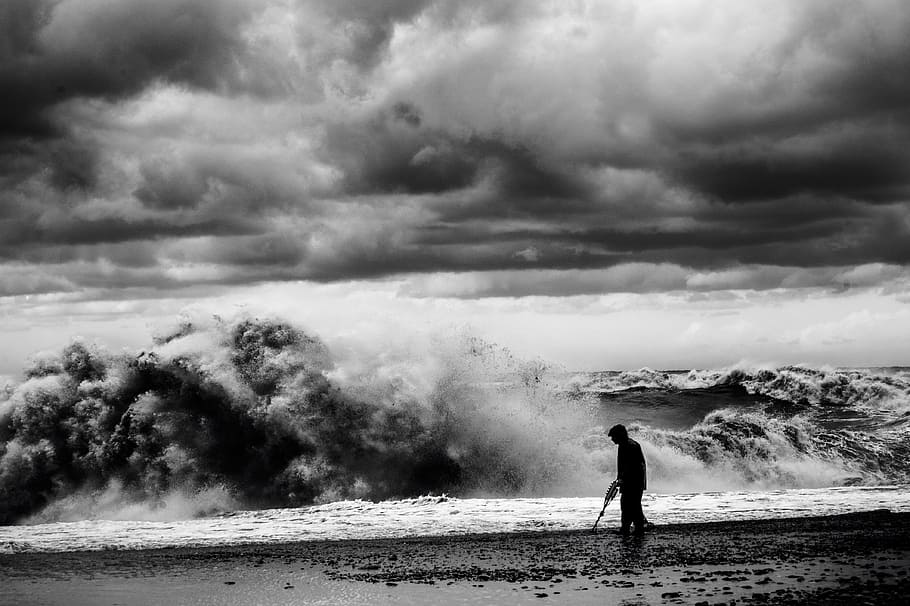 grayscale photo, man, walking, seashore, silhouette, shore, huge, waves, cloudy, sky, mountain, sea, wave, cloud, beach, coast, cloud - sky, one person, water, nature, beauty in nature, land, standing, day, power in nature, men, power, smoke - physical structure, scenics - nature, environment, outdoors, 4K